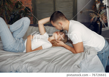 Couple sitting on a bed in a room 76726681
