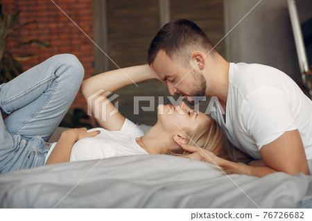 Couple sitting on a bed in a room 76726682