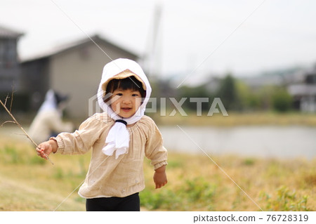 Children helping to plant rice 76728319