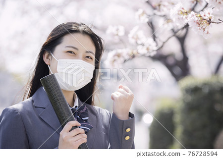 一個戴著面具的高中女生的畢業照，戴著文憑擺姿勢 76728594