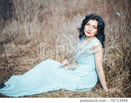 brunette girl in blue dress in forest brunette girl in blue dress in forest 76733466
