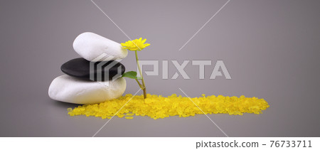Zen still life with stacked stones and yellow flower 76733711