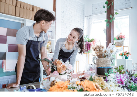 happy young man and female smiling talking while working together happy young man and female smiling talking while working together 76734748