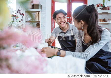portrait young couple wearing apron smiling talking while working together 76734831