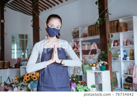 young woman manager wearing apron and face mask florist standing pose greeting young woman manager wearing apron and face mask florist standing pose greeting 76734842