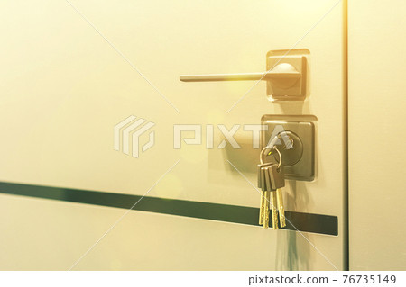 Keys stuck in a lock. closeup Door lock keys, Real estate concept door handle, Key insert and hold in metallic knob on white door horizontal. toned Keys stuck in a lock. closeup Door lock keys, Real estate concept door handle, Key insert and hold in metallic knob on white door horizontal. toned 76735149