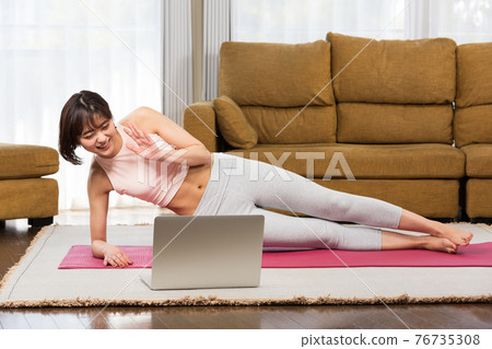 一位女士一邊看電腦一邊訓練 一位女士一邊看電腦一邊訓練 76735308