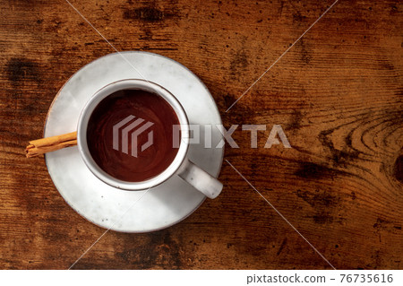 Hot chocolate cup, with a cinnamon stick, overhead shot with copyspace 76735616