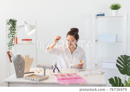 Professional accessories designer making handmade jewelry in studio workshop. Fashion, creativity and handmade concept. Professional accessories designer making handmade jewelry in studio workshop. Fashion, creativity and handmade concept. 76736979