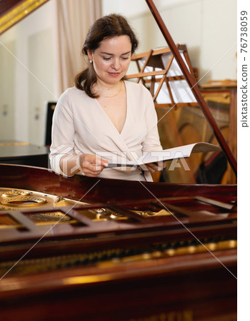 Saleswoman assistant in piano music store 76738059