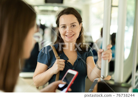 Positive woman traveling by city bus 76738244