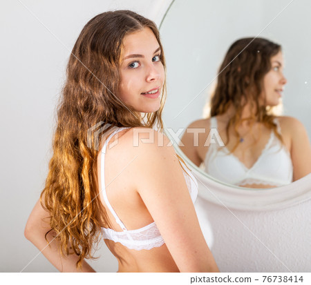 Girl in white lingerie posing near mirror in bedroom 76738414