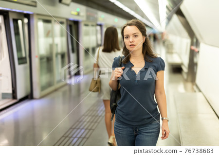 Woman waiting for train at underground station Woman waiting for train at underground station 76738683