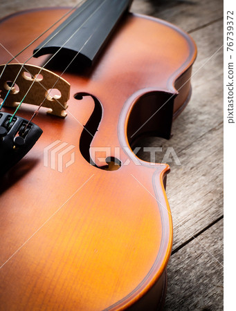 Closeup brown violin on wooden background. Art and music background. 76739372