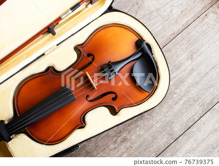 Brown violin in case over wooden background. Art and music background. Brown violin in case over wooden background. Art and music background. 76739375
