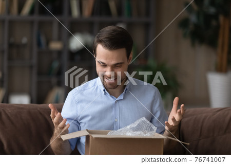 Excited man buyer overjoyed with good quality product 76741007
