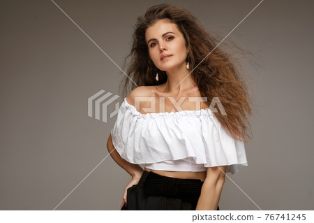 Beautifull caucasian woman with curly hair smiles 76741245