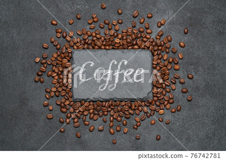 Background or texture made of roasted brown coffee beans and stone serving board with chalk handwritten sign 76742781
