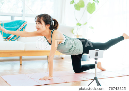 一個年輕的女人，做瑜伽在線 76742825