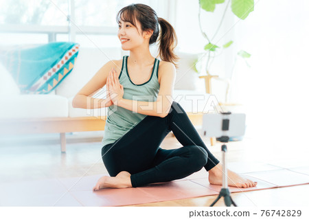 A young woman doing yoga online A young woman doing yoga online 76742829
