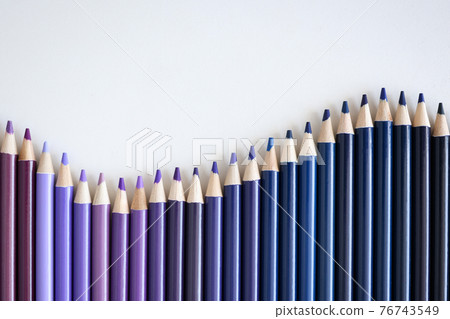 Many shades of blue and purple pencils lying on white background closeup 76743549