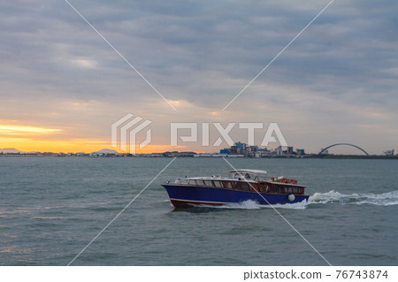 Motor yacht cruising in a sea and beautiful sunset and blue water. Vessel 76743874