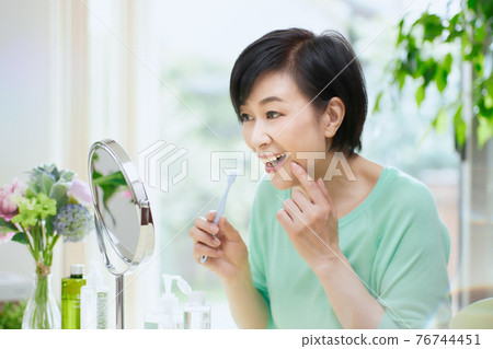 Middle woman with a toothbrush in the living room 76744451