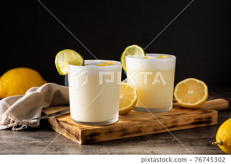 Pisco sour cocktail on wooden table. Traditional peruvian cocktail Pisco sour cocktail on wooden table. Traditional peruvian cocktail 76745302