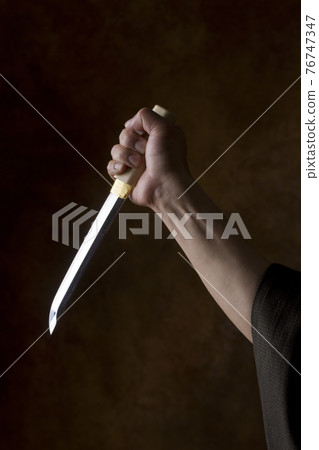 拿著劍的男人的手 76747347