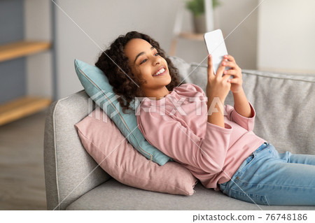 Drone courier flying up with carton package in city 76748186