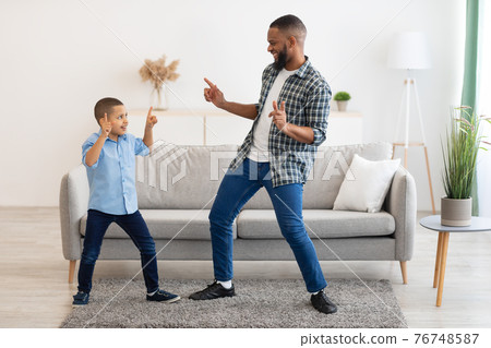 African Dad And Little Son Dancing Having Fun At Home 76748587