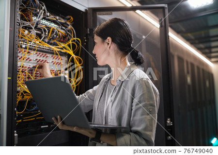 Female Network Technician Connecting Cables 76749040
