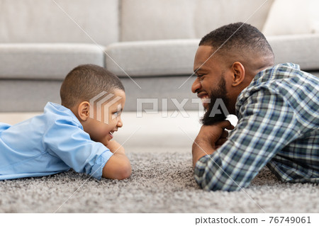 African Daddy And Son Looking At One Another At Home African Daddy And Son Looking At One Another At Home 76749061