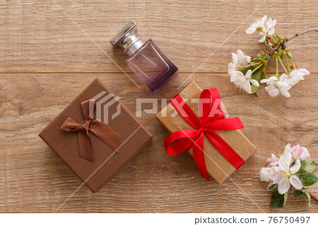Gift boxes with cherry flowers on the wooden background. 76750497