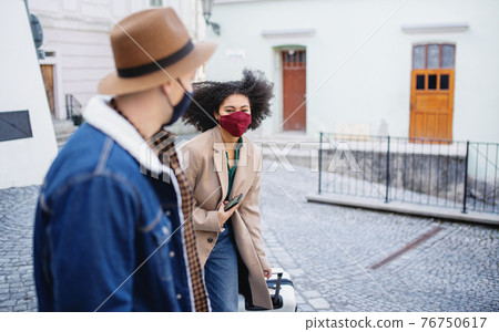 Young couple tourists with luggage walking on streets in old town, coronavirus concept. Young couple tourists with luggage walking on streets in old town, coronavirus concept. 76750617
