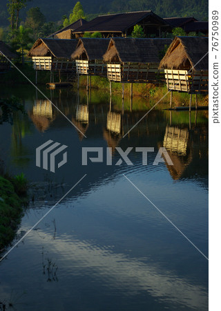 In the morning light small huts beside the lake and the mountain view 76750989