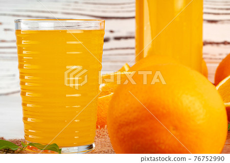 Close up of orange juice glass on wooden table Close up of orange juice glass on wooden table 76752990