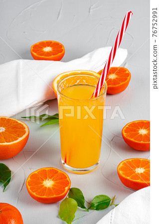 Glass of orange juice with red straw on table Glass of orange juice with red straw on table 76752991