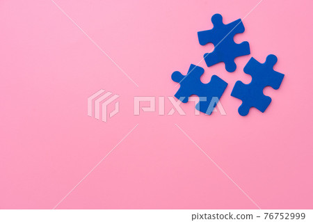 Blue puzzle pieces on paper background top view 76752999