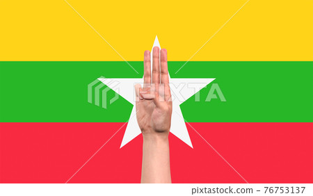 The three finger of Myanmar man raised as a protest sign with Myanmar flag background The three finger of Myanmar man raised as a protest sign with Myanmar flag background 76753137