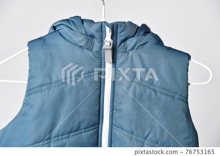 Trendy blue sleeveless vest on hanger in human Trendy blue sleeveless vest on hanger in human 76753165