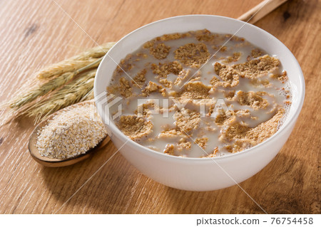 Oats milk and cereals on wooden table. Oats milk and cereals on wooden table. 76754458