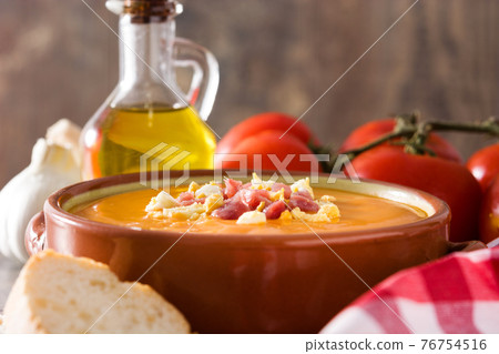 Typical Spanish salmorejo cream with ham and egg on wooden table Typical Spanish salmorejo cream with ham and egg on wooden table 76754516