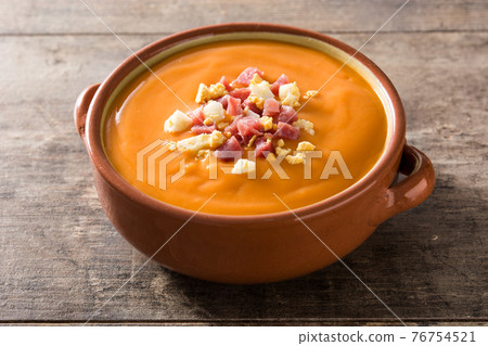 Typical Spanish salmorejo cream with ham and egg on wooden table Typical Spanish salmorejo cream with ham and egg on wooden table 76754521