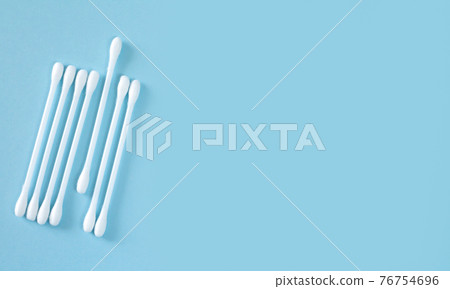 Flay lay of white plastic cotton sticks or swabs top view on blue background 76754696