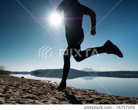 Silhouette young sport man running outdoors on beach Silhouette young sport man running outdoors on beach 76757209