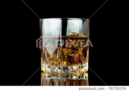 Glass of whiskey and ice. 76758259