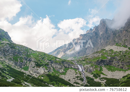 Mountain stream with view of rocky mountains at good weather. Mountain stream with view of rocky mountains at good weather. 76758612