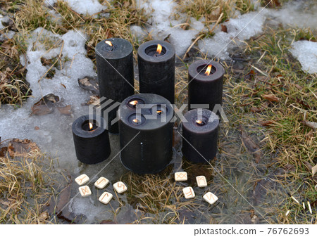 Magic ritual with black candles and runes in winter outside. Esoteric, gothic and occult background, Halloween mystic and wicca concept outdoors. 76762693