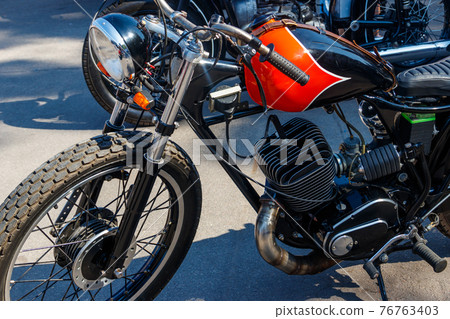 Close-up of motorcycle parked on city street 76763403
